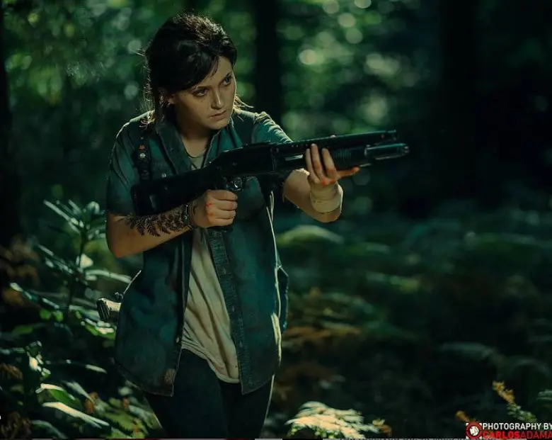 Cosplay de Ellie de The Last of Us Part II no meio da mata empunhando uma espingarda.