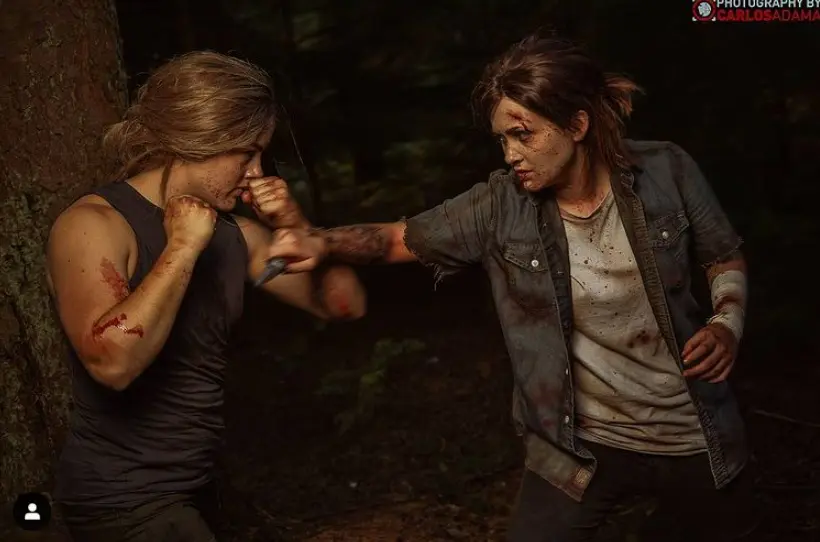 Cosplays de Abby e Ellie de The Last of Us Part II simulando uma briga do jogo.