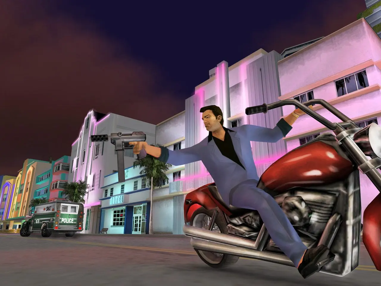 Tommy Vercetti, de GTA Vice City, jogo de PlayStation 2, em uma moto enquanto aponta uma metralhadora para alguém.