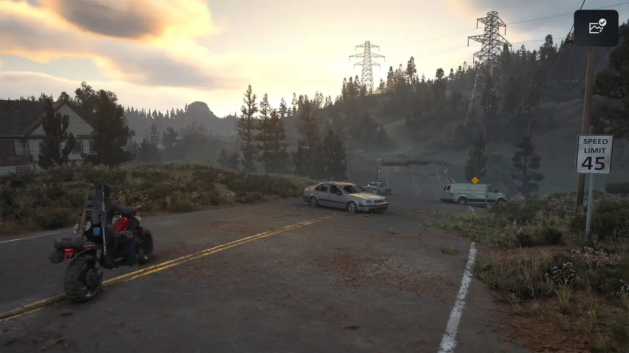 Imagem do protagonista de Days Gone sentado em sua moto no meio de uma rua com carros na sua frente e um cenário pós-apocalíptico