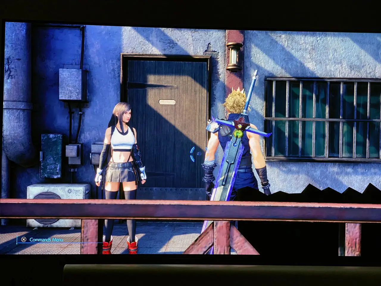 Imagem de Final Fantasy VII Remake de PS5 com o protagonista Cloud de costas e a Tifa de frente, com uma porta em destaque