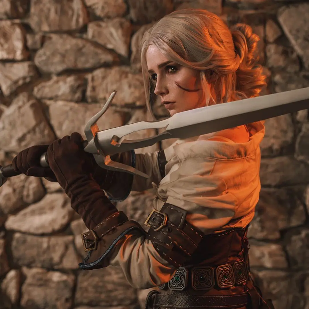 Imagem do cosplay da personagem Ciri, de The Witcher 3, fazendo uma pose e segurando uma espada
