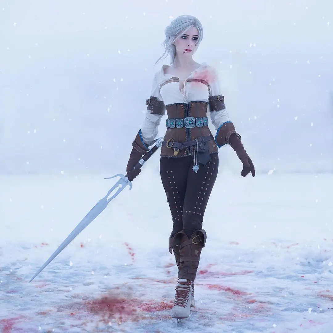 Imagem do cosplay da personagem Ciri, de The Witcher 3, de frente segurando uma espada