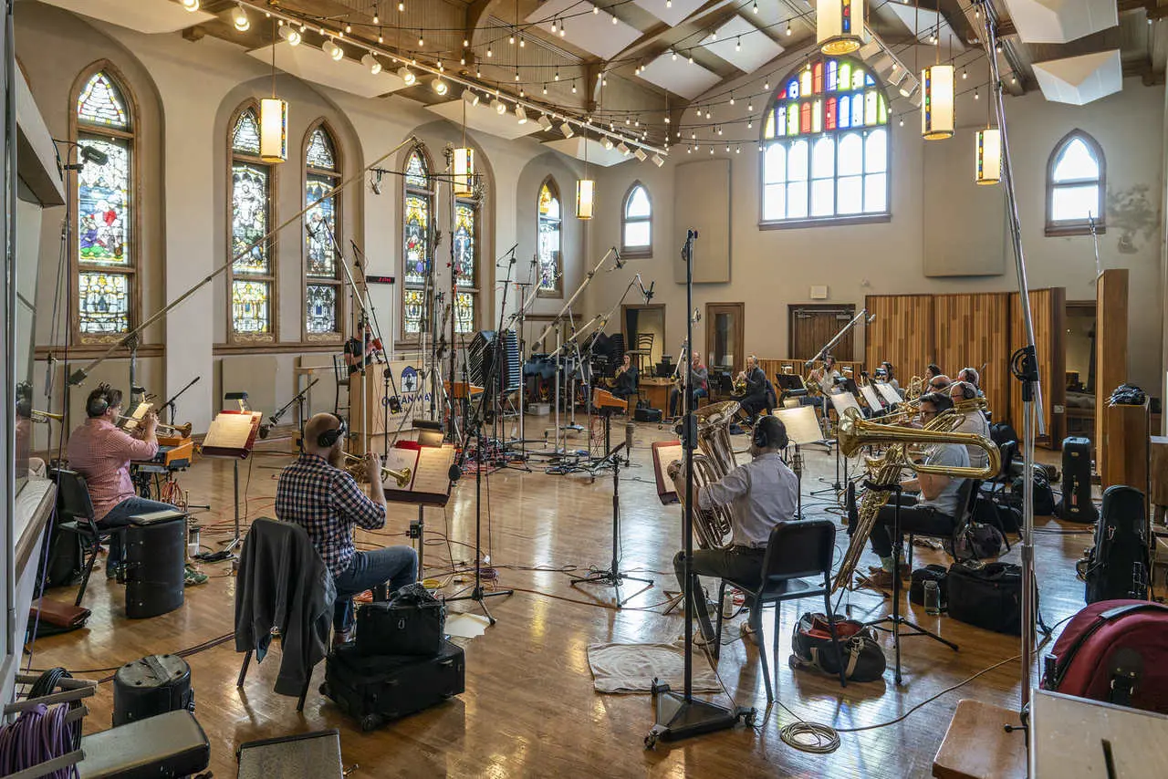 Imagem de uma sessão de gravação orquestral do novo Ratchet & Clank com diversos músicos tocando instrumentos