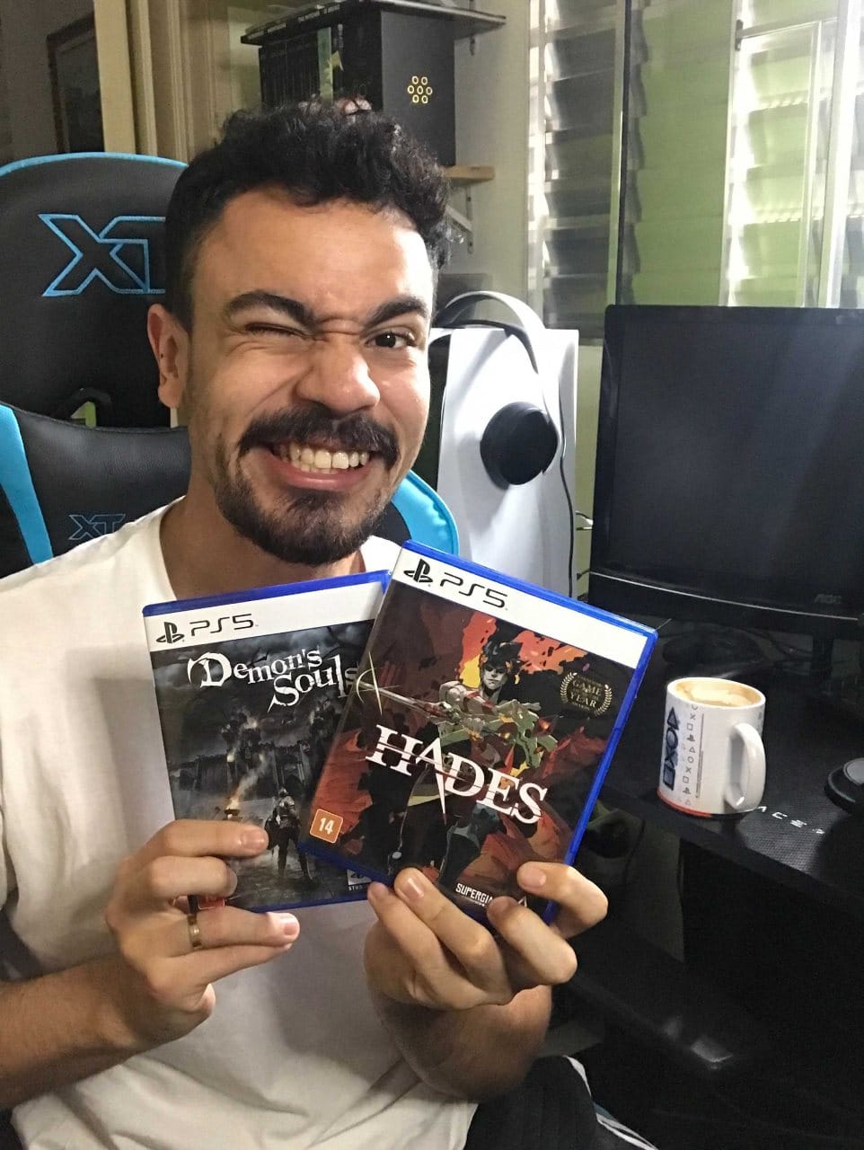 Raphael Batista, streamer do MeuPS, com cópias de Demon's Souls e Hades nas mãos