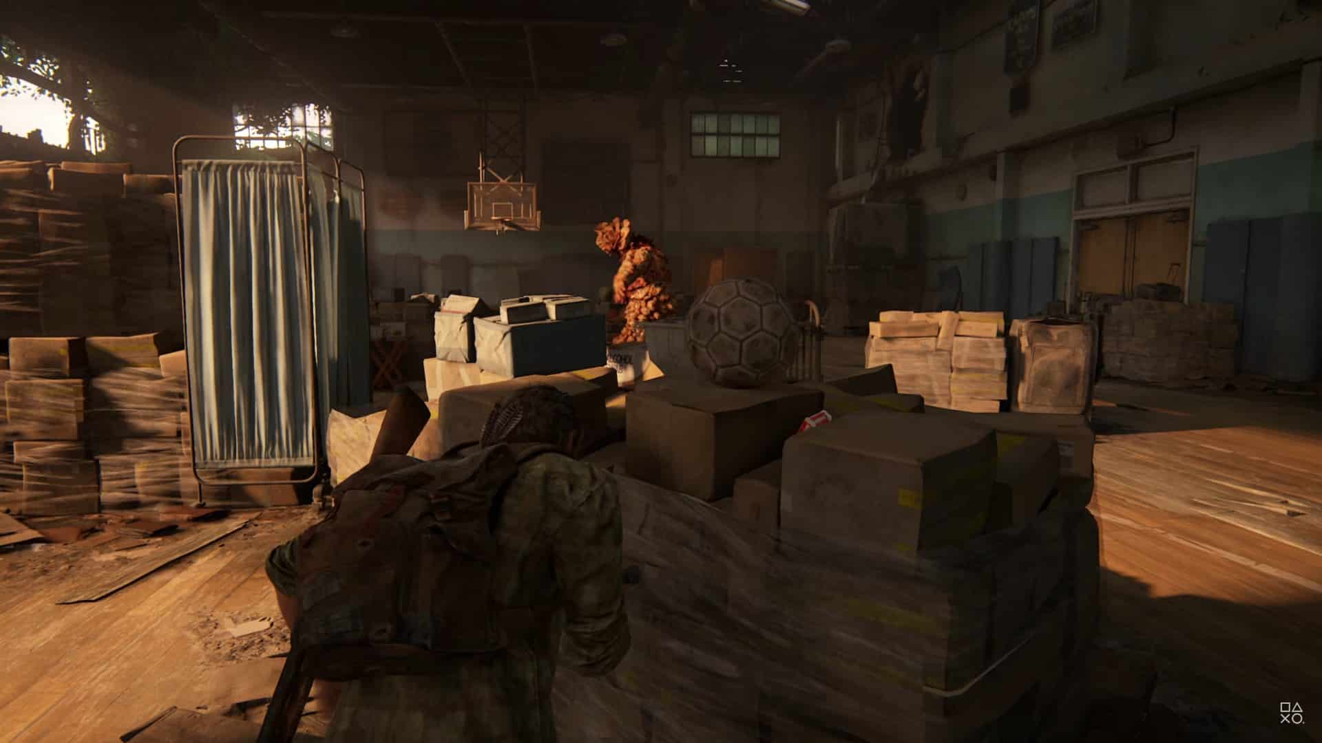 Joel se escondendo do inimigo no ginásio em The Last of Us Part I
