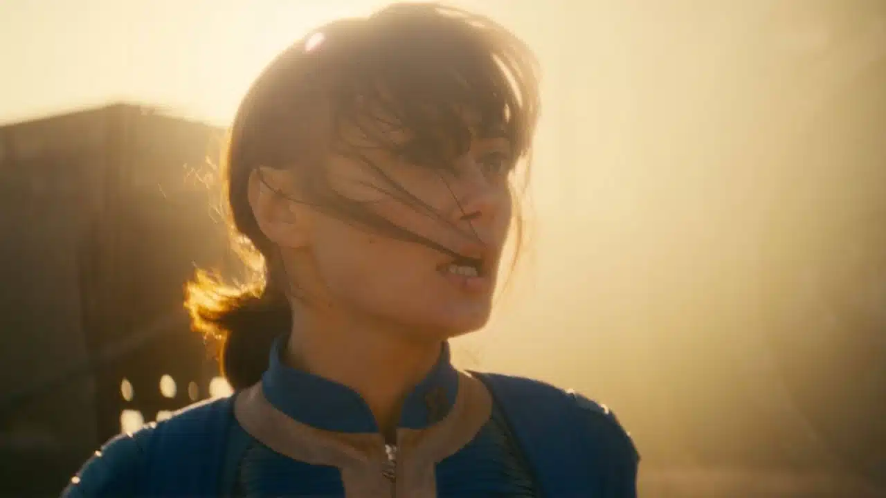 mulher de cablo preso e roupa azul olha para a distância em um cenário de por do sol