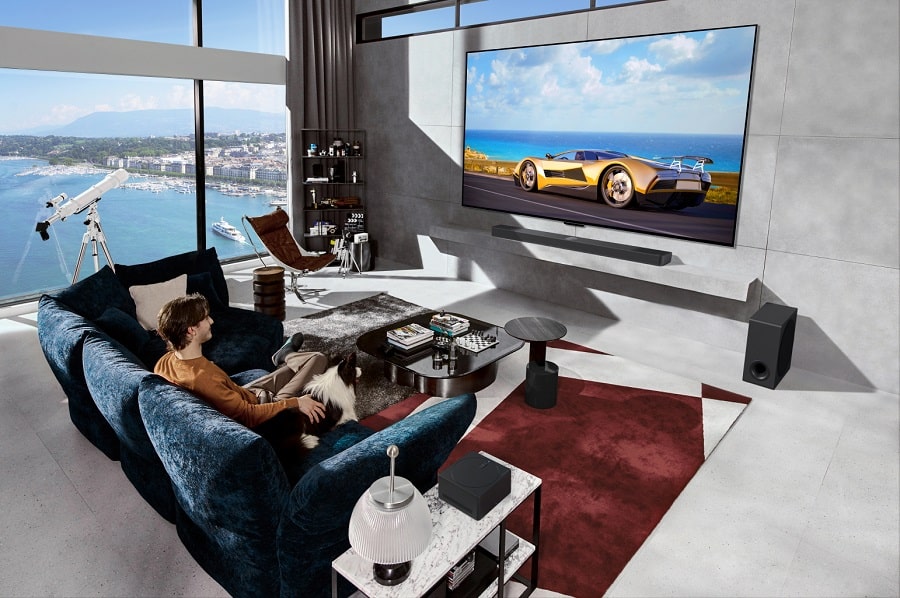 Imagem destaca nova TV OLED da LG na sala, com pessoa sentada no sofá assistindo.