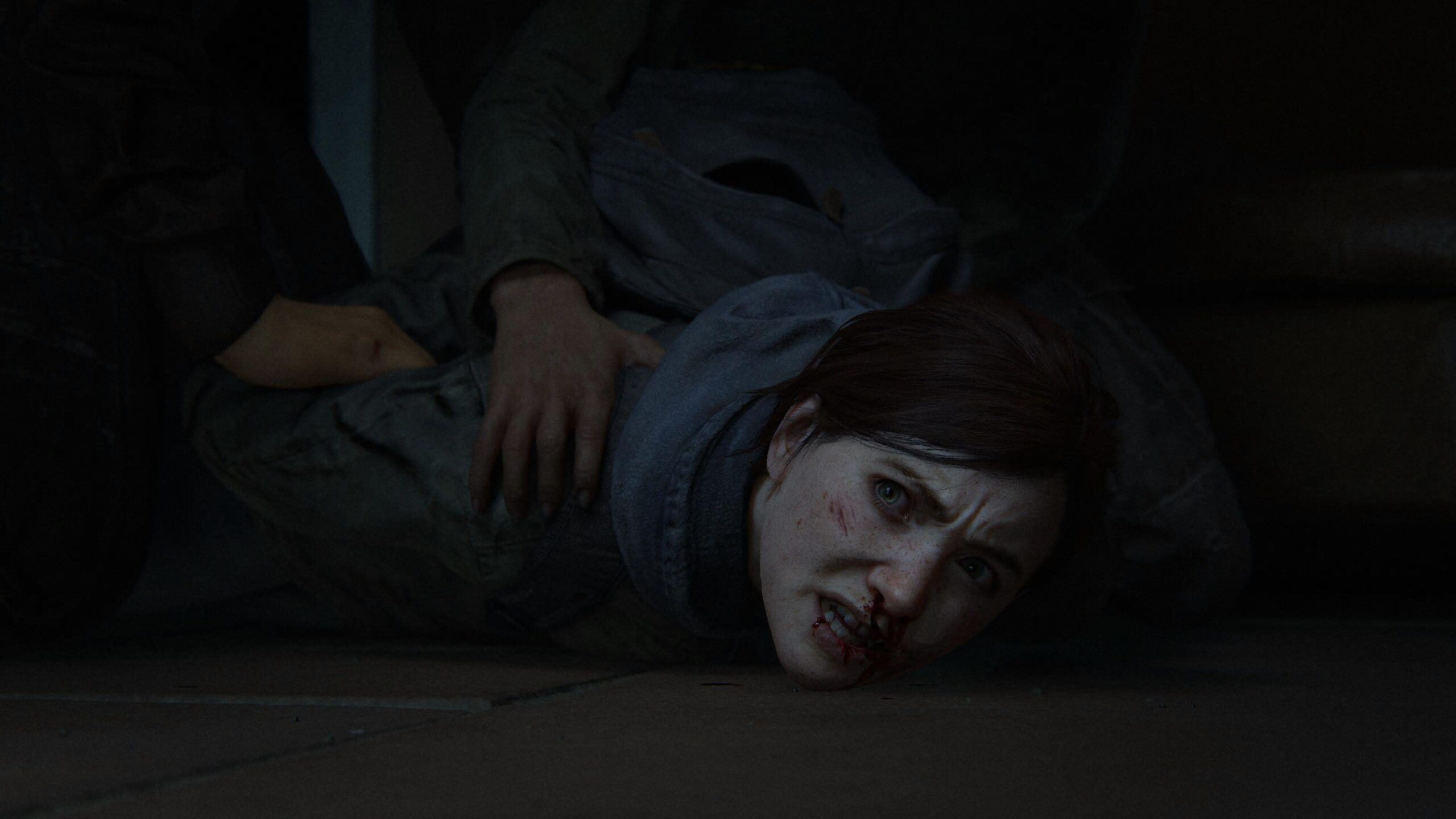 Ellie sendo segurada por pessoas em The Last of Us Part II