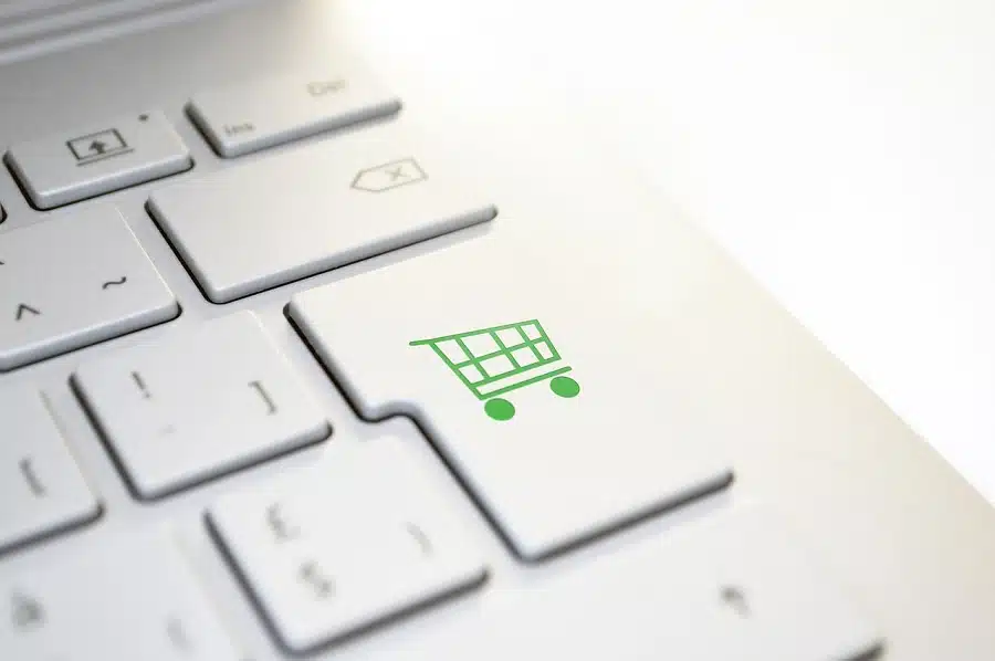 Foto mostra carrinho de compras no lugar do enter do teclado, para ilustrar compras pela internet.