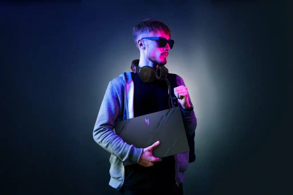  rapaz segurando notebook gamer nitro v 15 no braço