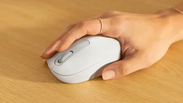 Imagem mostra mão segurando um M196, destacando tamanho compacto do mouse.